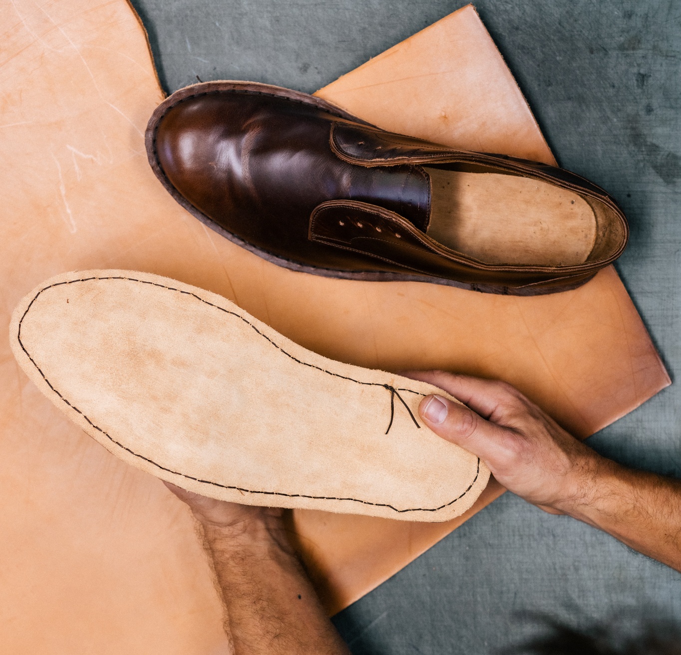 A pair of brown shoes sitting on top of a wooden table.