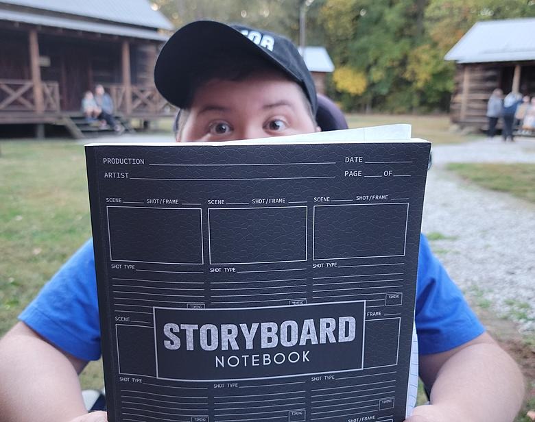 Noah on set of his short film “The Soda” with his storyboard notebook