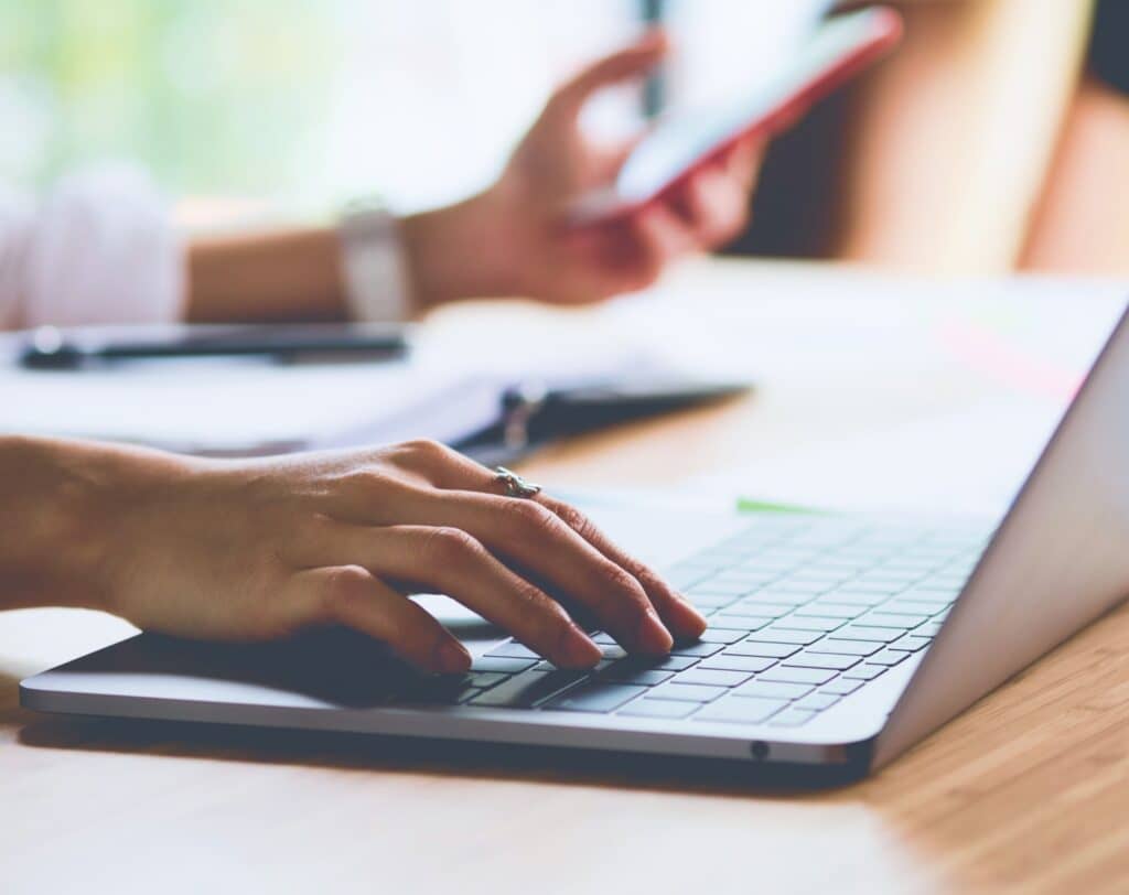 Pessoa usando notebook para entender a diferença entre investimento e despesa