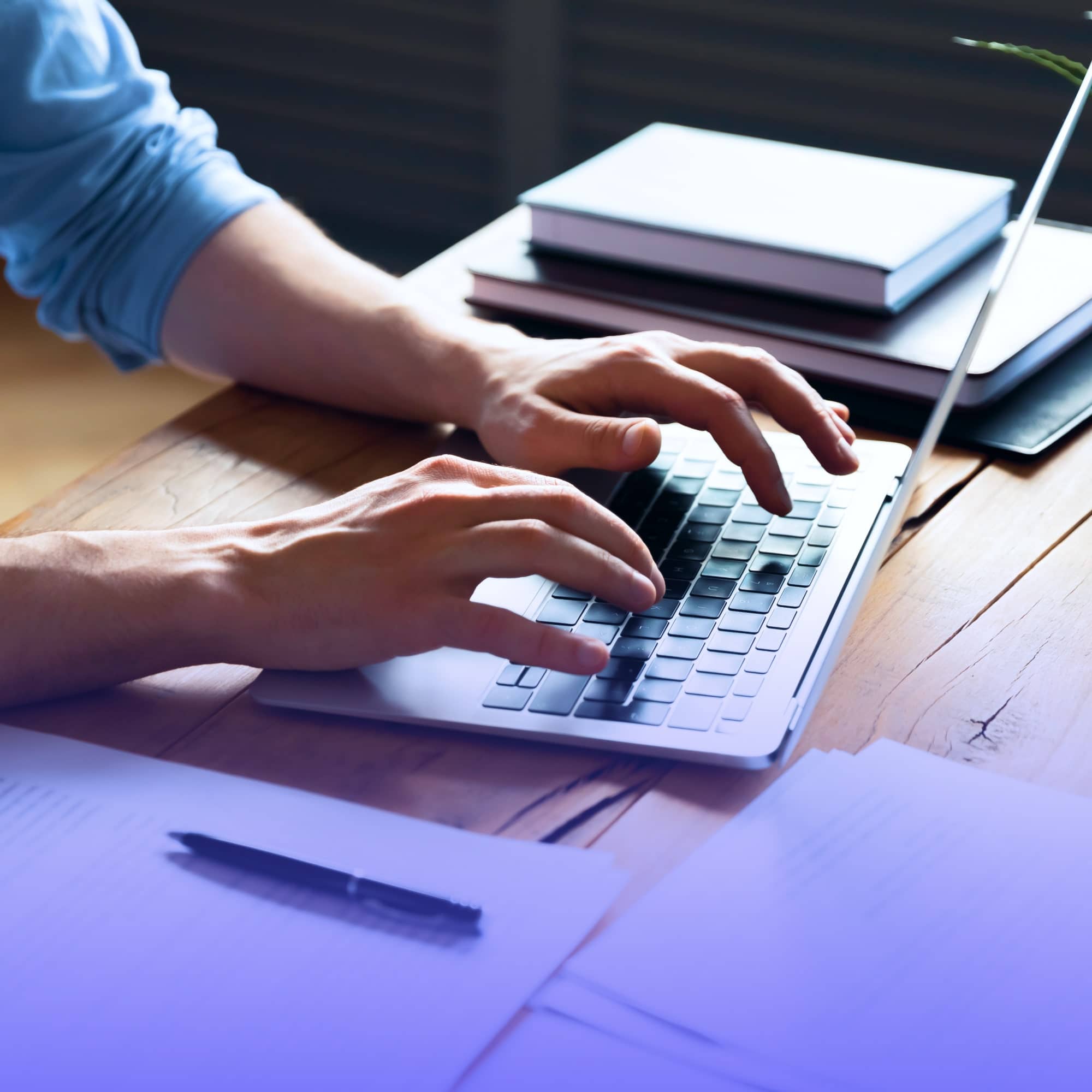 Pessoa digitando em notebook para aprender como consultar o IPTU pelo CPF no site da prefeitura.