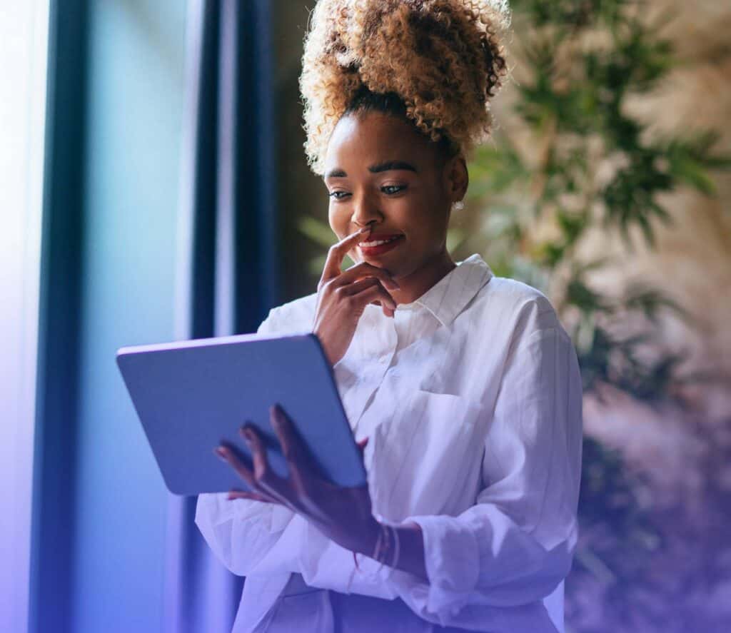 Pessoa analisando dados financeiros em tablet para entender rendimento, lucro e desempenho de investimentos.