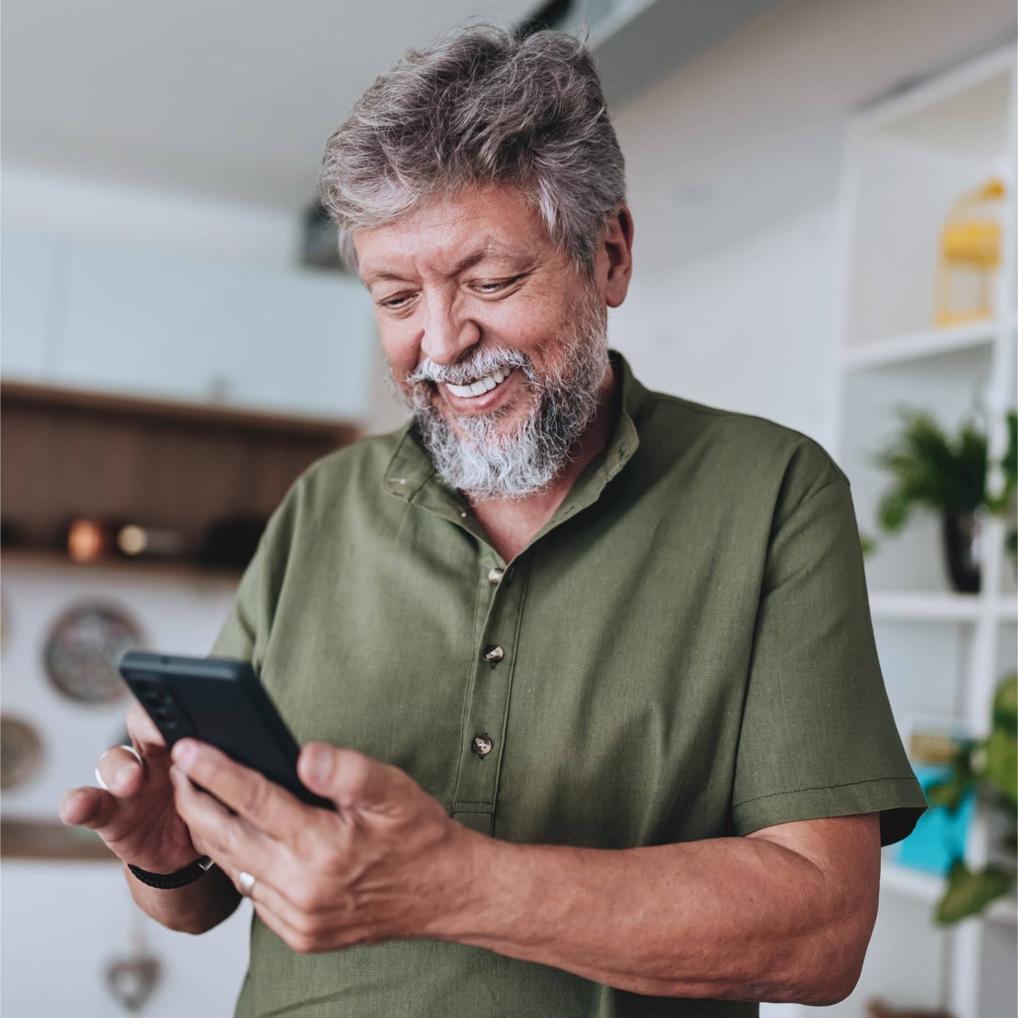 Homem sorrindo enquanto usa o celular para entender como funciona o lance no consórcio