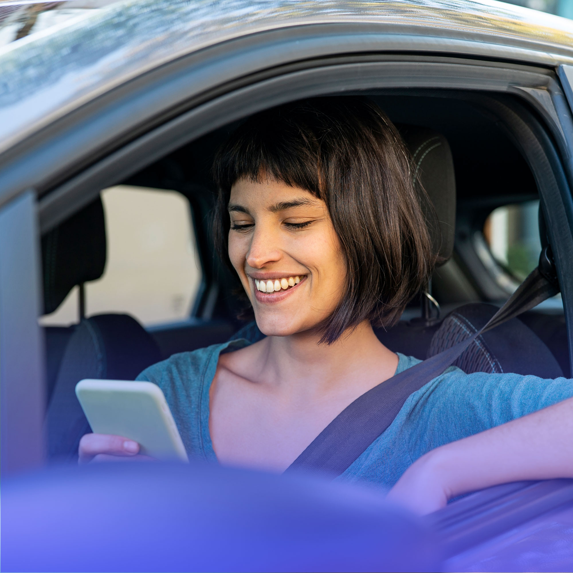 Mulher usando o celular dentro de um carro para ilustrar como usar FGTS para comprar carro