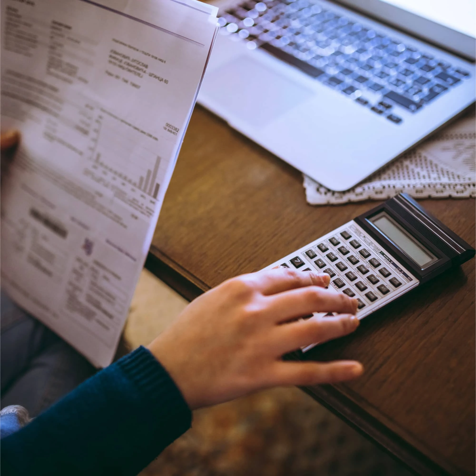 Pessoa analisando documentos e calculando valores para quitar financiamento