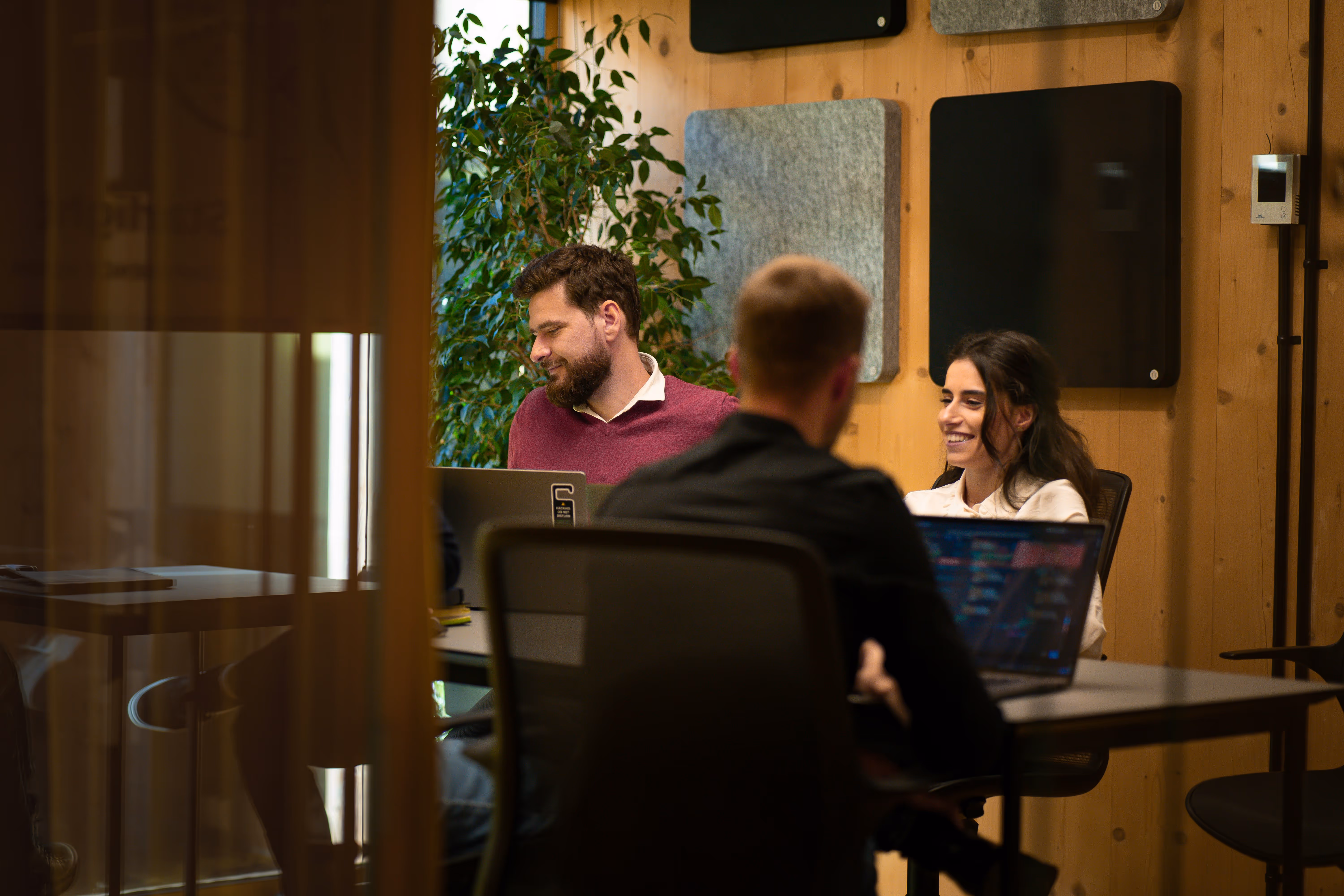 Three people around table with laptops