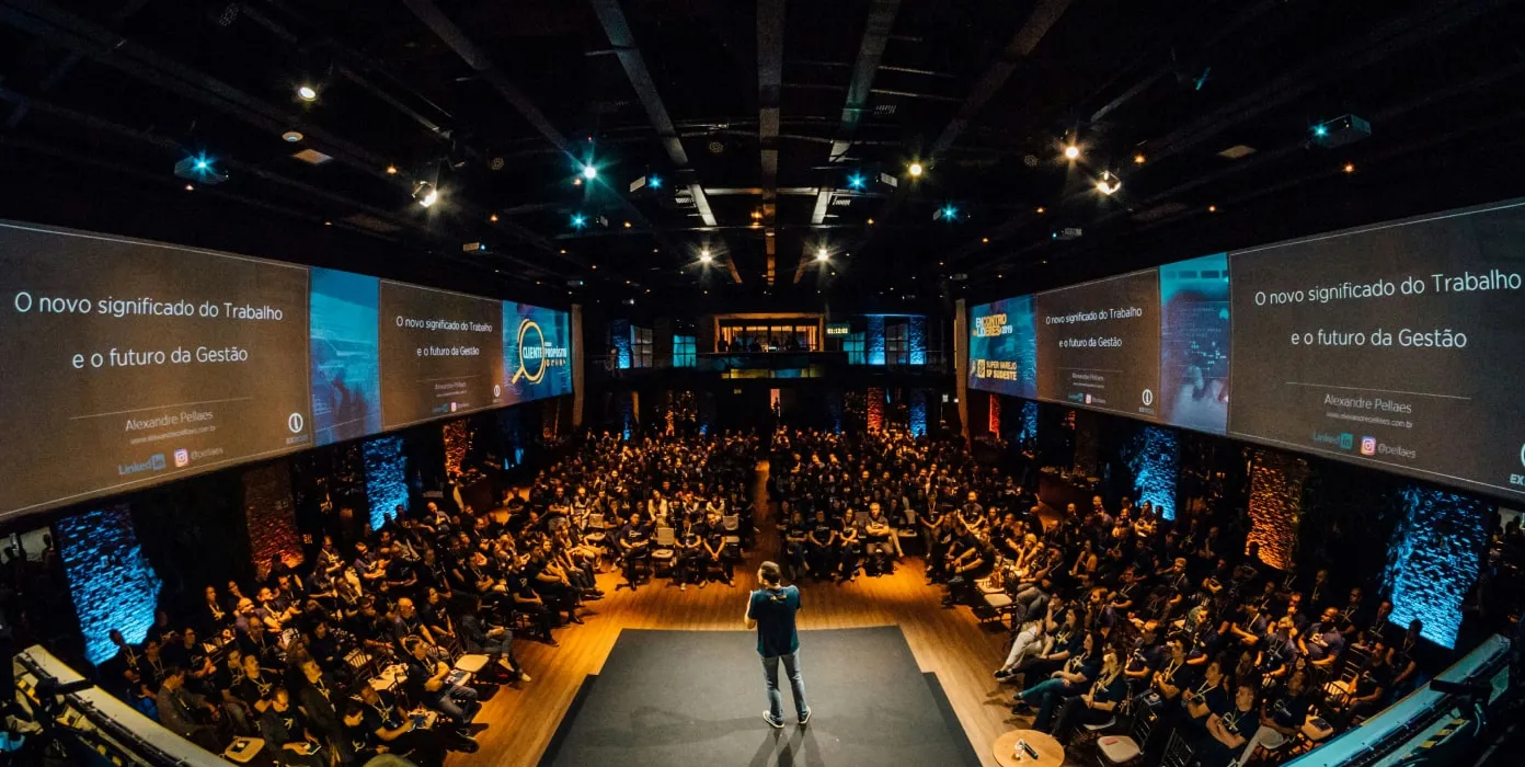 a man standing on a stage in front of a crowd of people