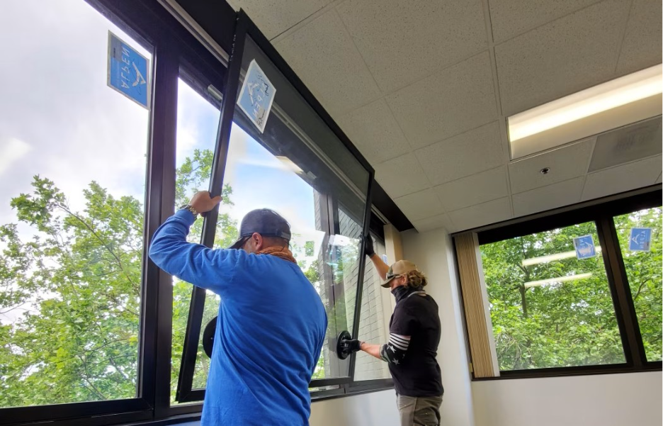Two people installing WinSert, a secondary window insert
