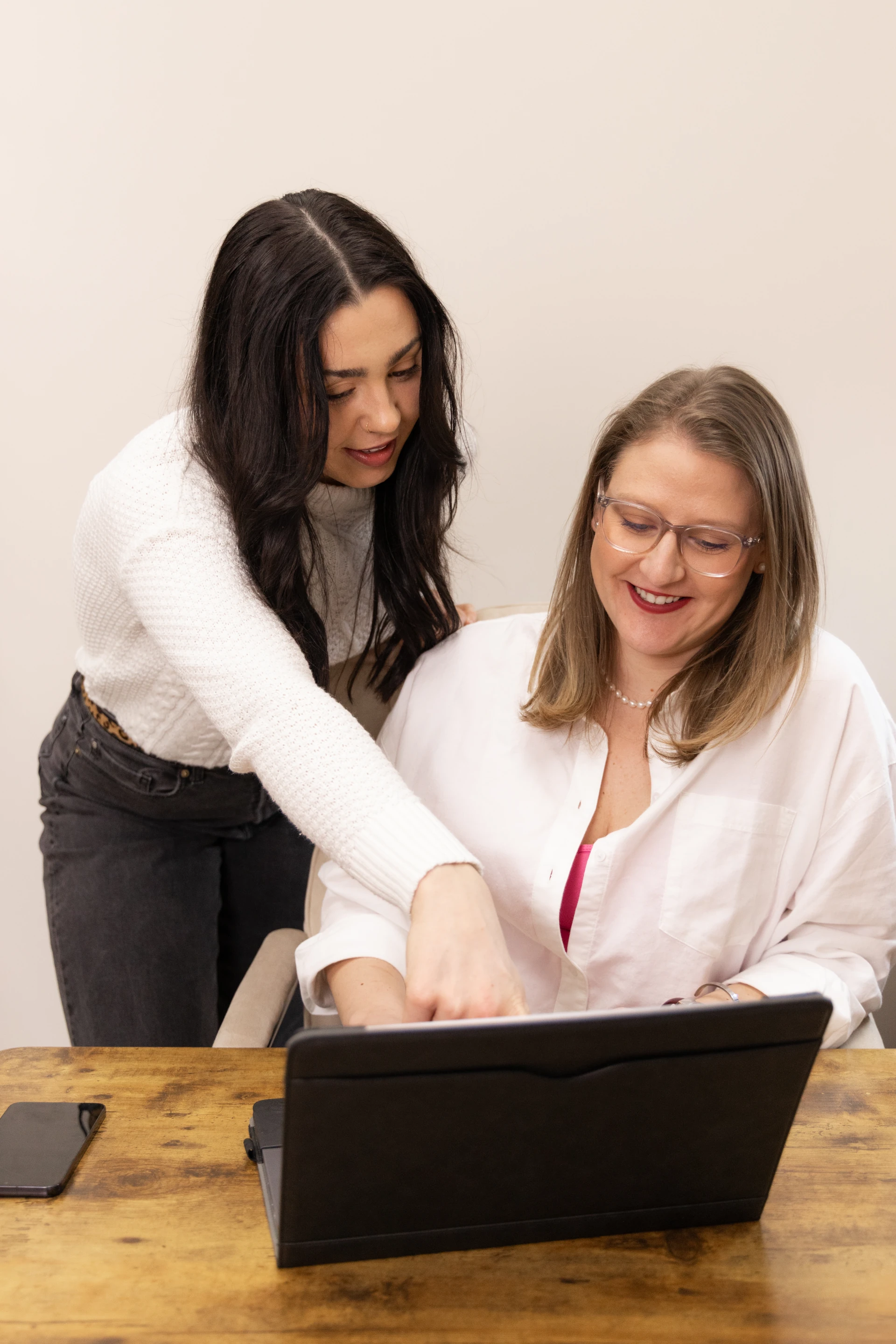 2 women looking at and pointing to a laptop