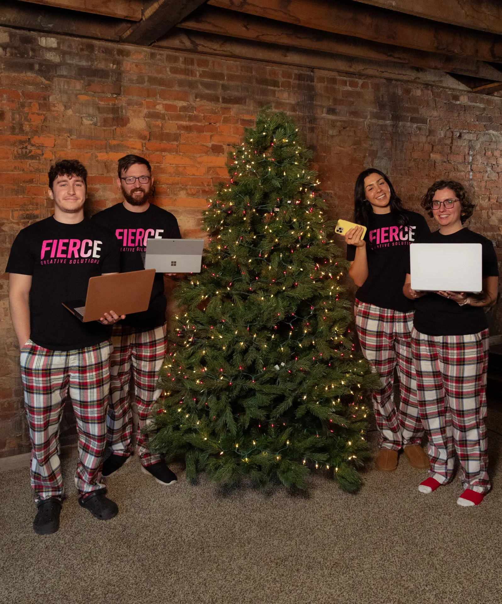 4 members of the Fierce team standing around a christmas tree