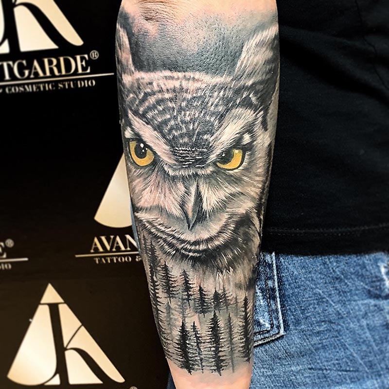 Eulenmotiv mit gelben Augen als Tattoo am Unterarm.