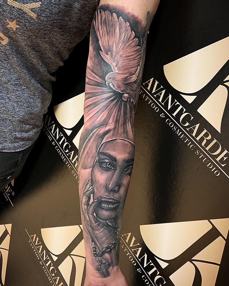 Schwarzgraues Tattoo mit einer Figur und strahlenförmigem Hintergrund.