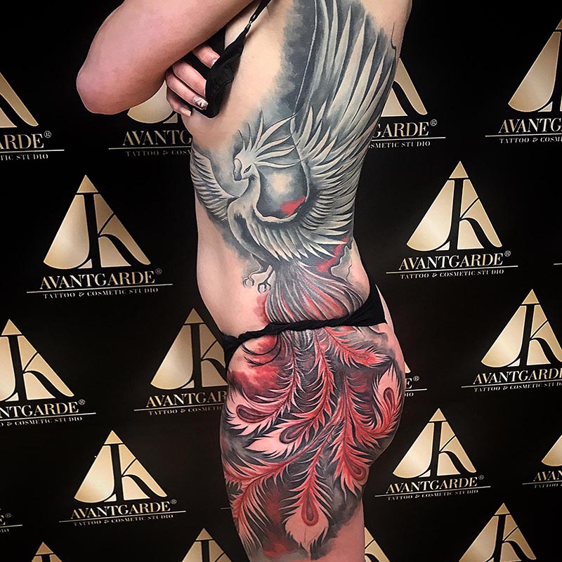 Tattoo mit einer Feder und einer roten Rose am Arm.