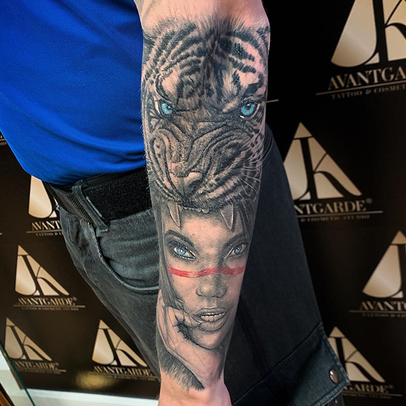 Tattoo mit Tigerkopf und Gesichtsporträt in Schwarzgrau mit roten Akzenten.