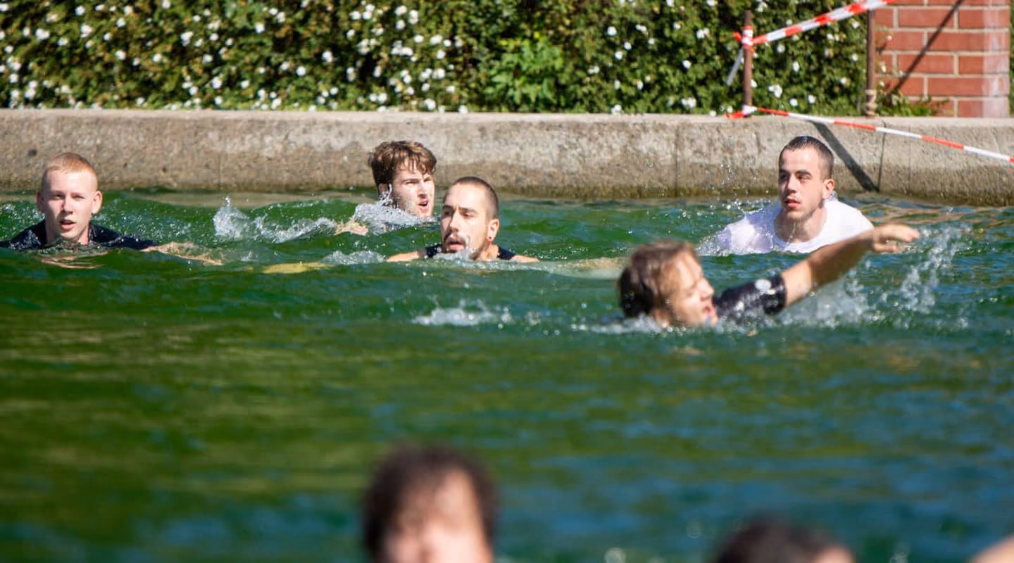 Hindernis des Elements "Wasser". Die Teilnehmer durchqueren das Freibad Mildenau.
