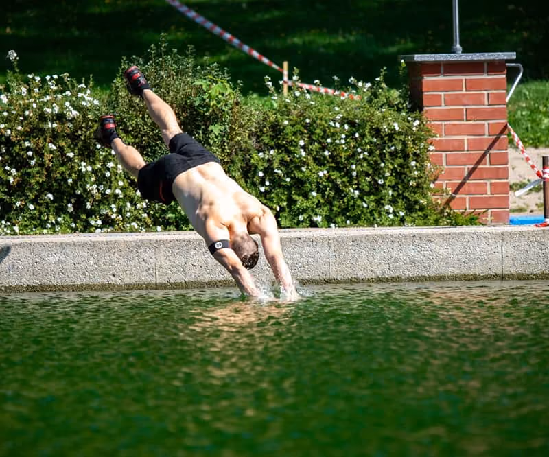 Ein Teilnehmer springt ins Wasser des Freibades