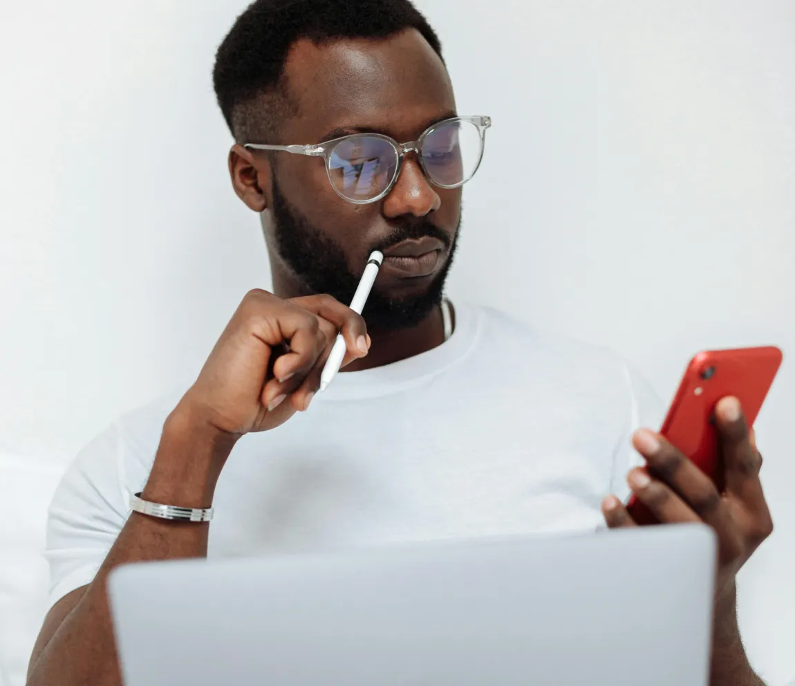 Healthcare professional analyzing patient data on a smartphone and laptop, representing Momentum’s tailored AI agent development for improving patient care and operational efficiency in HealthTech applications.