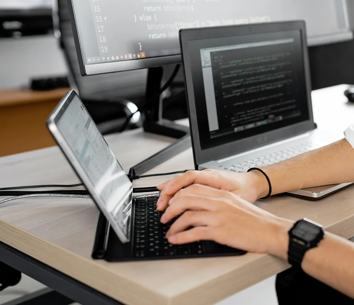 Software engineer developing AI prototypes on a laptop, with code displayed on multiple screens, highlighting Momentum’s fast, iterative HealthTech app development for scalable healthcare solutions.