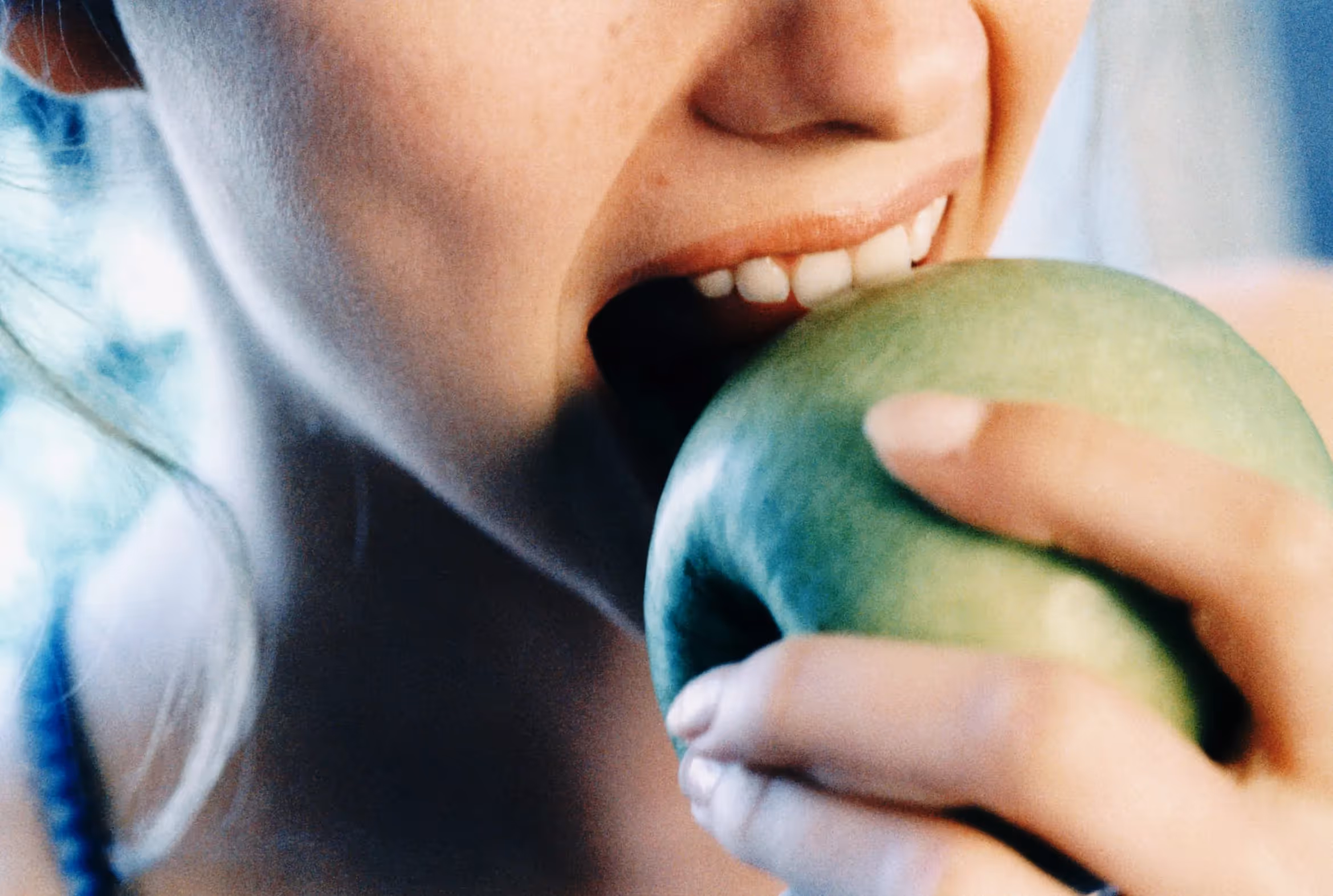 A picture of a person biting into an apple