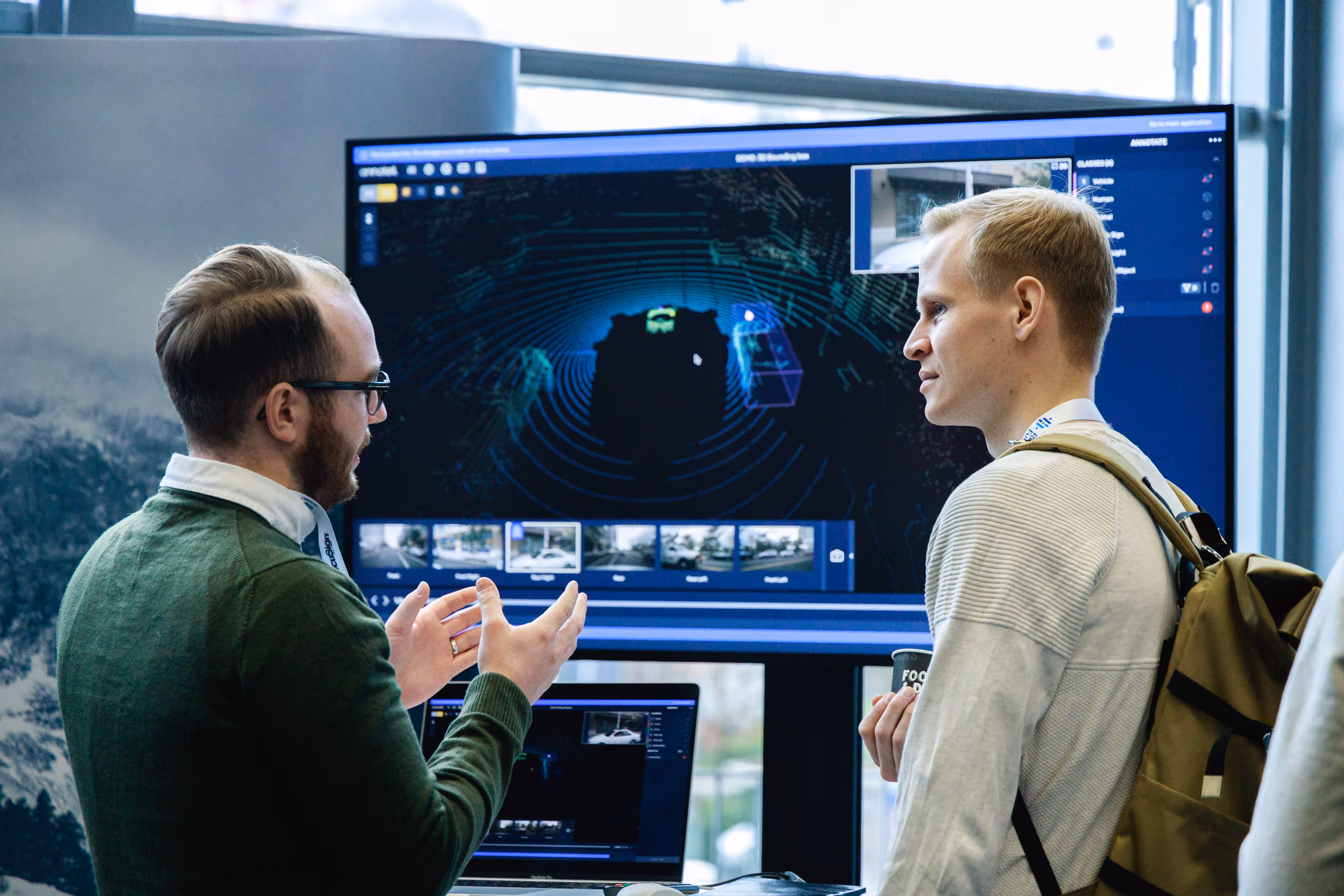 A photo of a partner booth at the 2022 GAIA Conference with two people in front of a screen. Photo by Viktor Antončić.