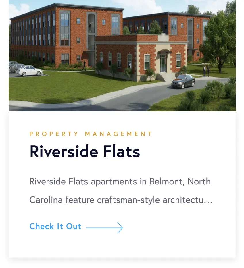 Exterior view of Riverside Flats, a red brick apartment complex in Belmont, North Carolina, with cars parked and people walking nearby.
