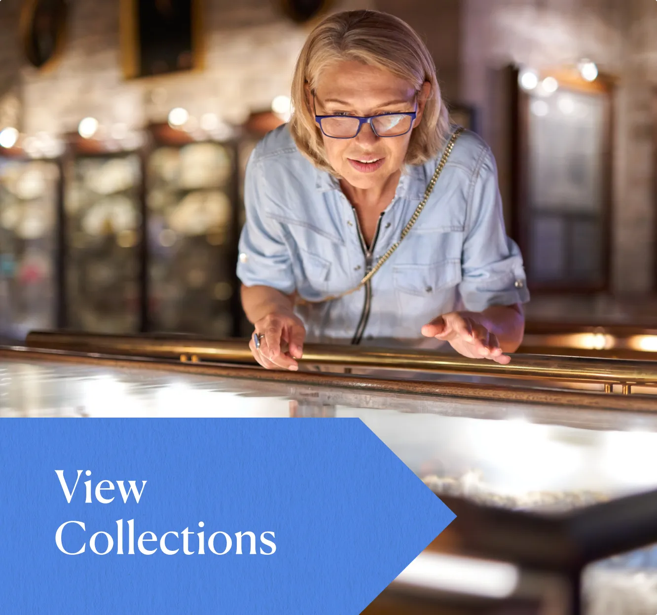 A card from Greensboro History Museum website with a woman looking at a table and a blue arrow that says "View Collections"