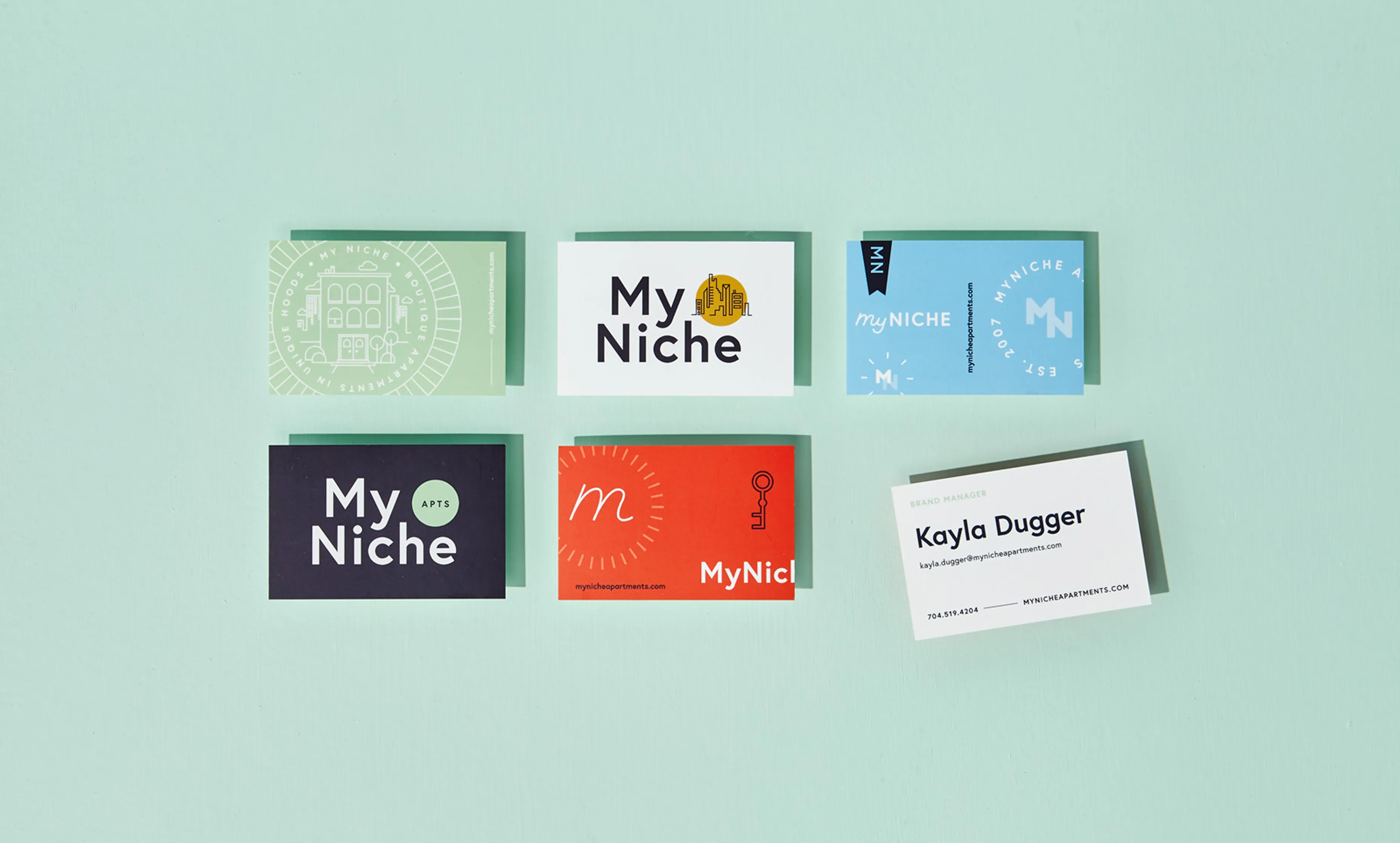 Six colorful business cards on a light green background, featuring 'MyNiche' branding and contact information for Kayla Dugger.