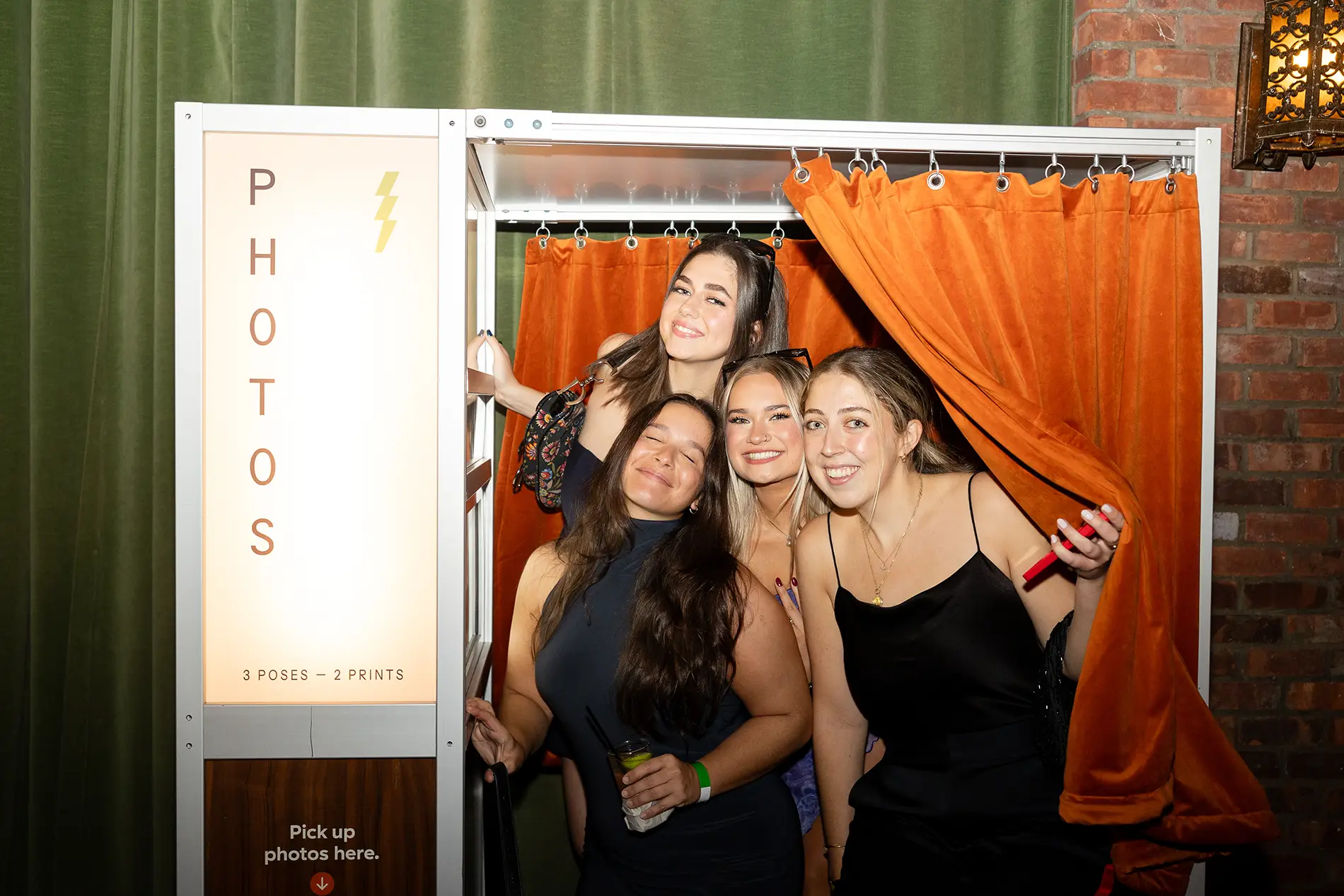 Three women in a photo booth and wondering about the photo booth prices