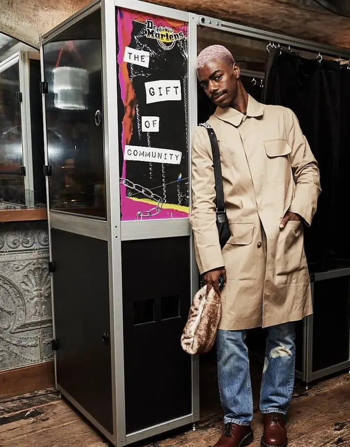 A person poses next to a photo booth and wonders how much is it to rent a photo booth