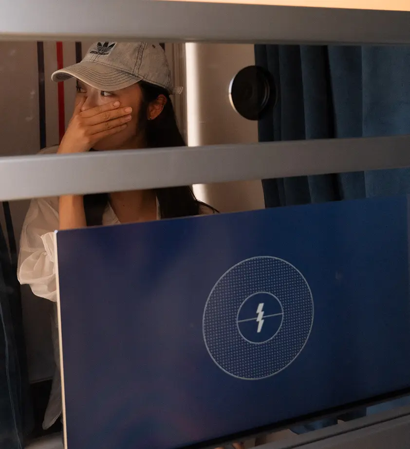 Guest wearing an Adidas cap laughing inside the photo booth with the touchscreen camera display visible