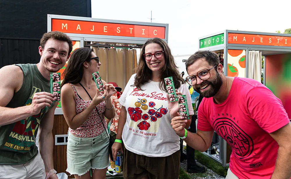 Four people holding their personal photo strips