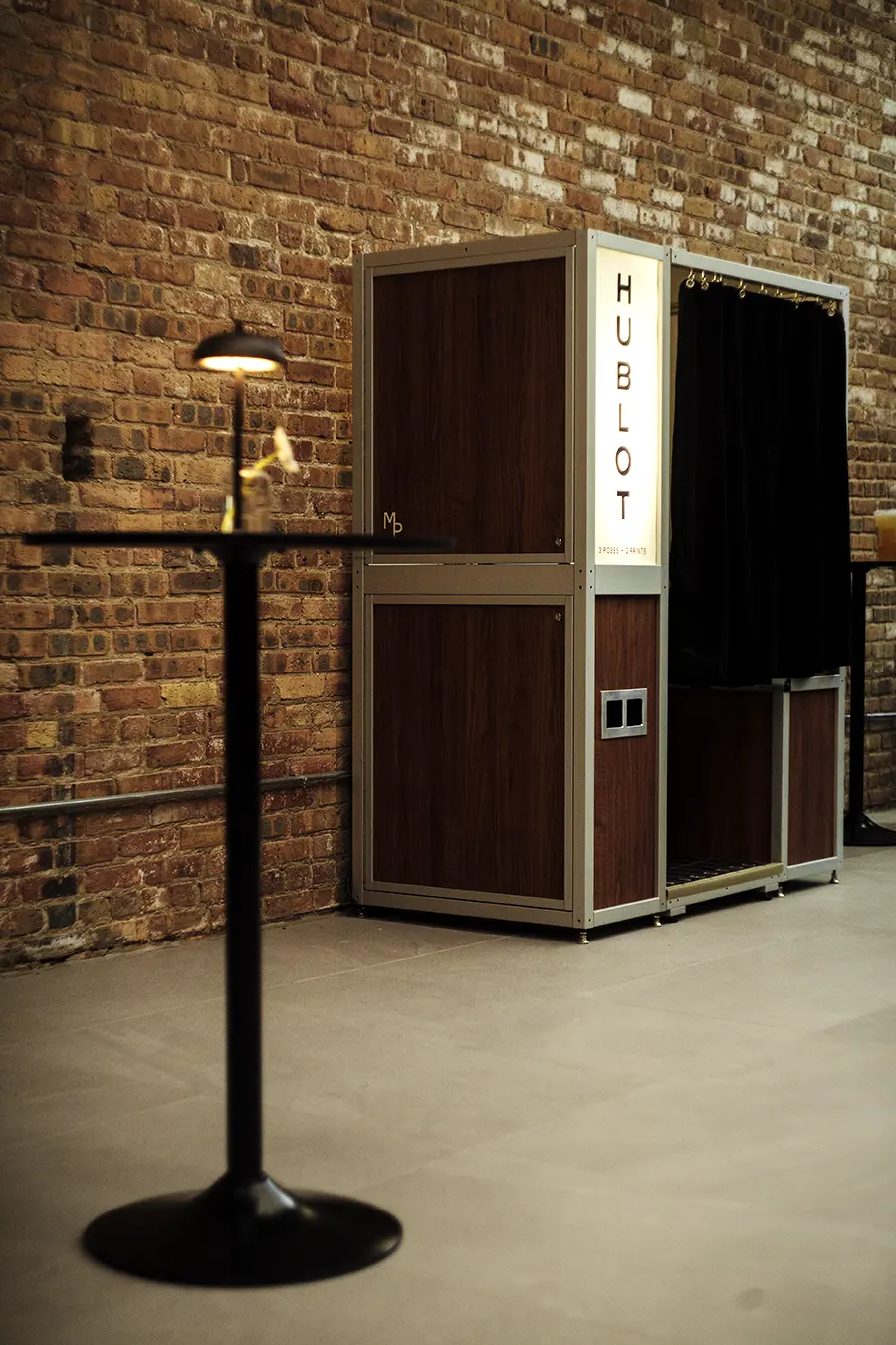 The Hublot photo booth in the corner of the boutique beside cocktail tables during the Fulton Market grand opening reception