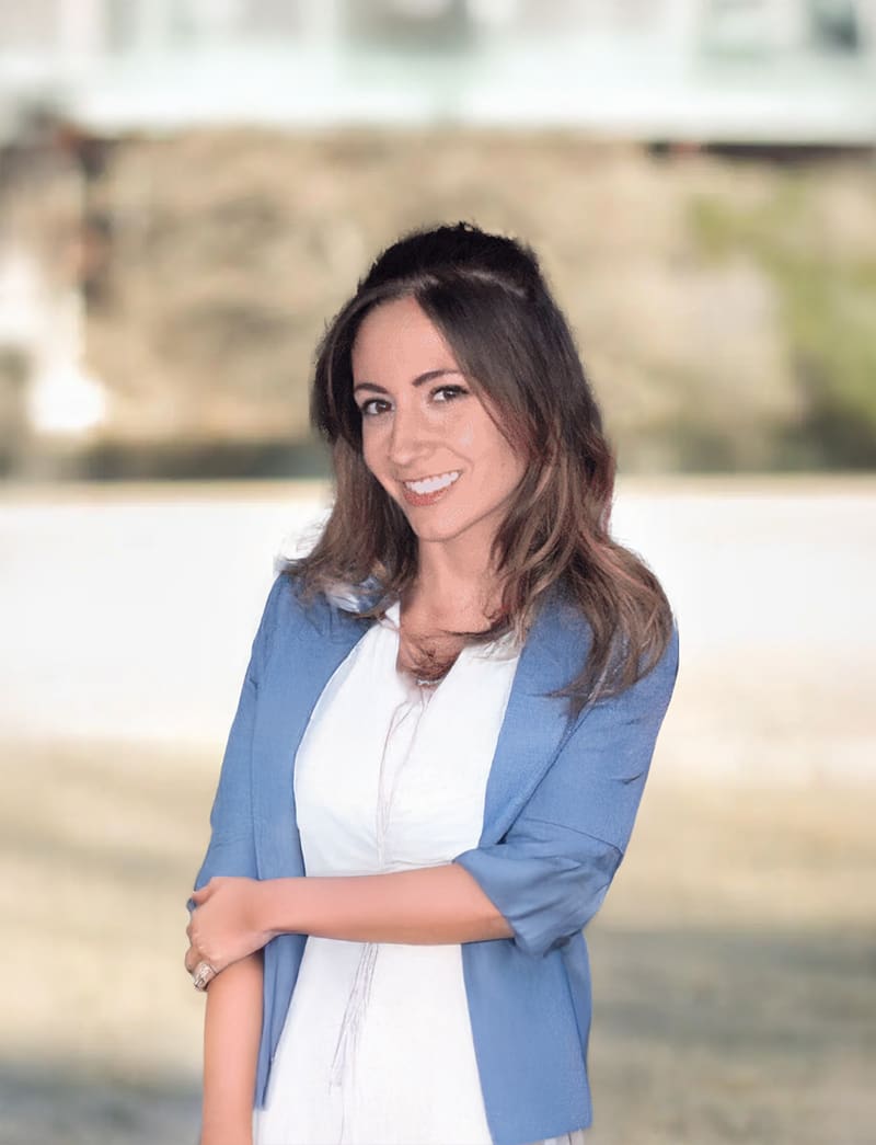 Smiling woman in blue blazer outside.