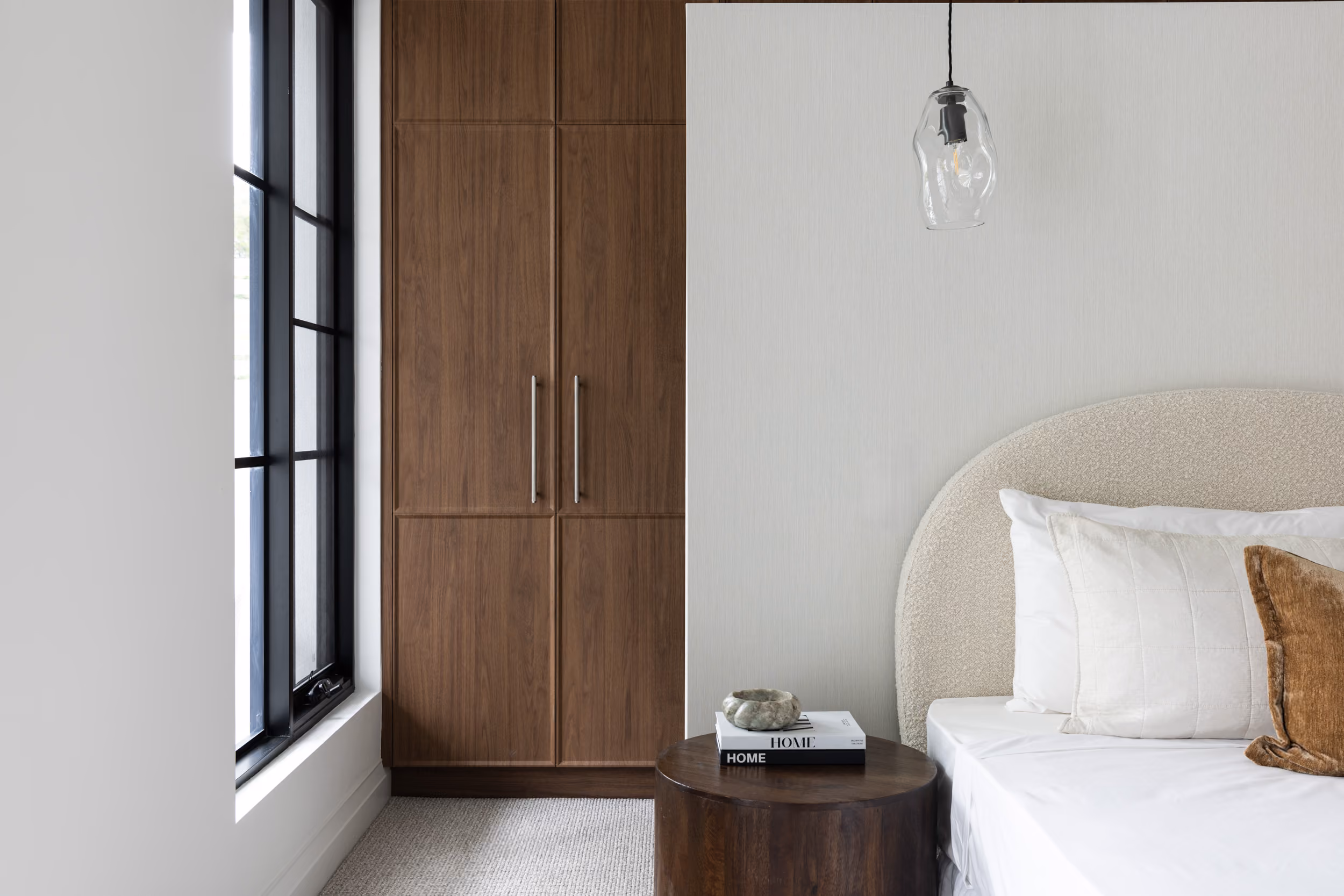 Bright bedroom with timber wardrobe and soft bedding