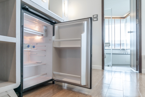 Modern compact minibar fridge with organised drinks storage in a hotel or home setting