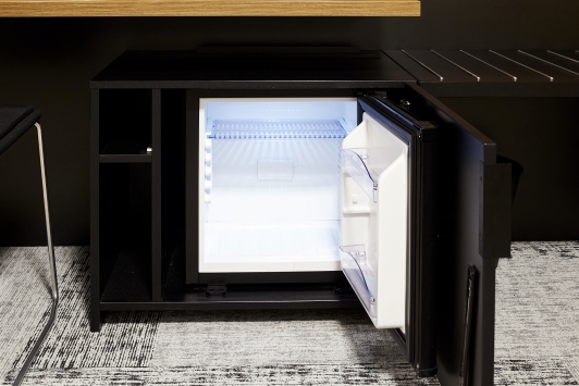 Stylish compact minibar fridge providing convenient chilled drink storage in a modern interior