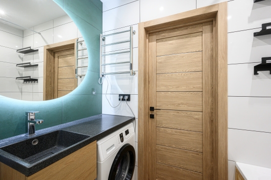 Integrated washing machine fitted into a modern kitchen with coordinated cabinets and practical laundry storage