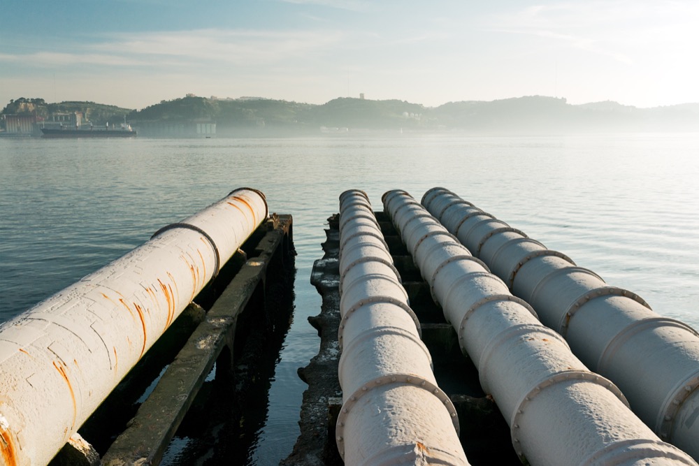 Pipes Above the lake with the shore and the city in the distance