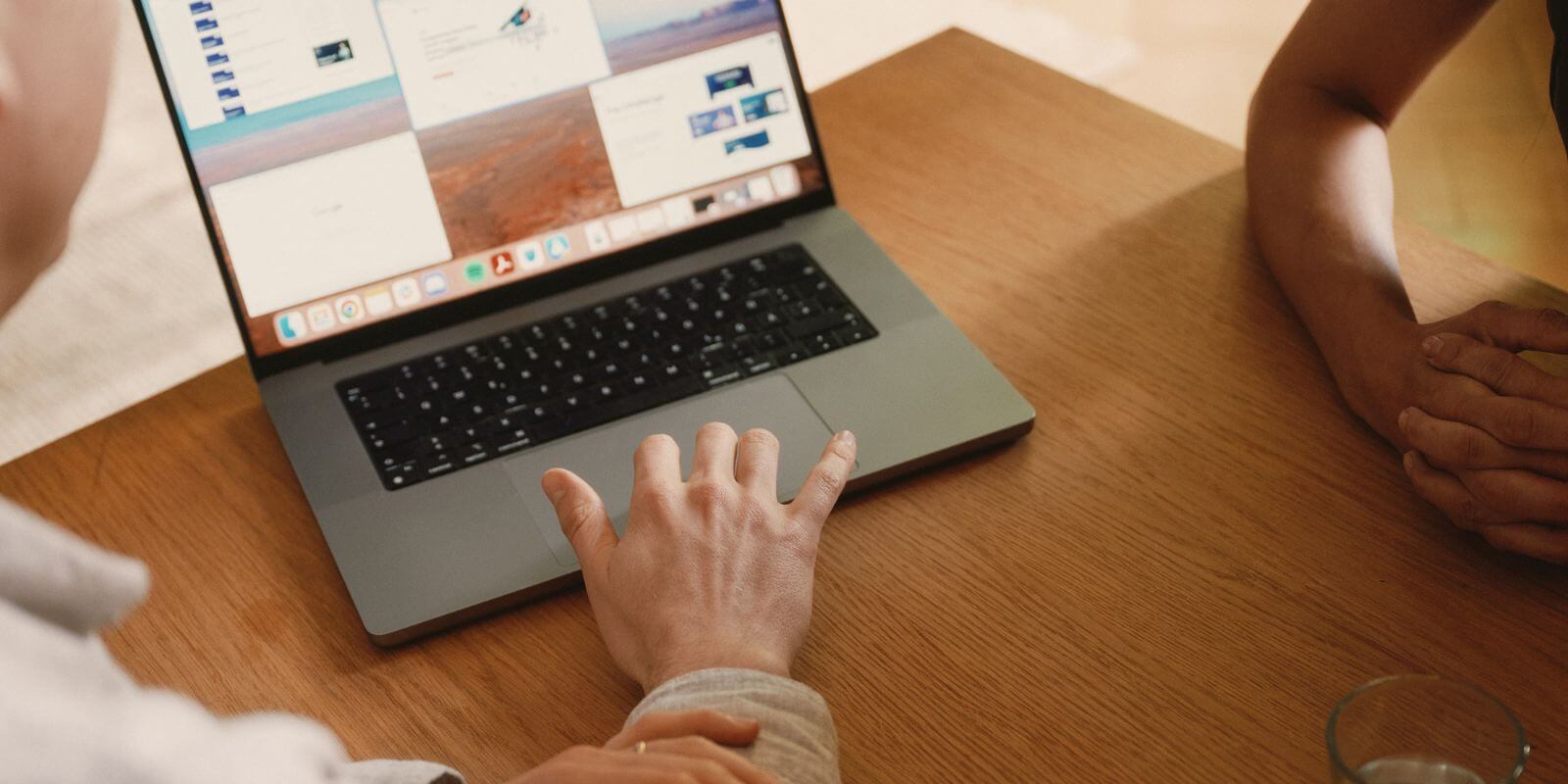 Mann zeigt auf Laptopo verschiedene Screens
