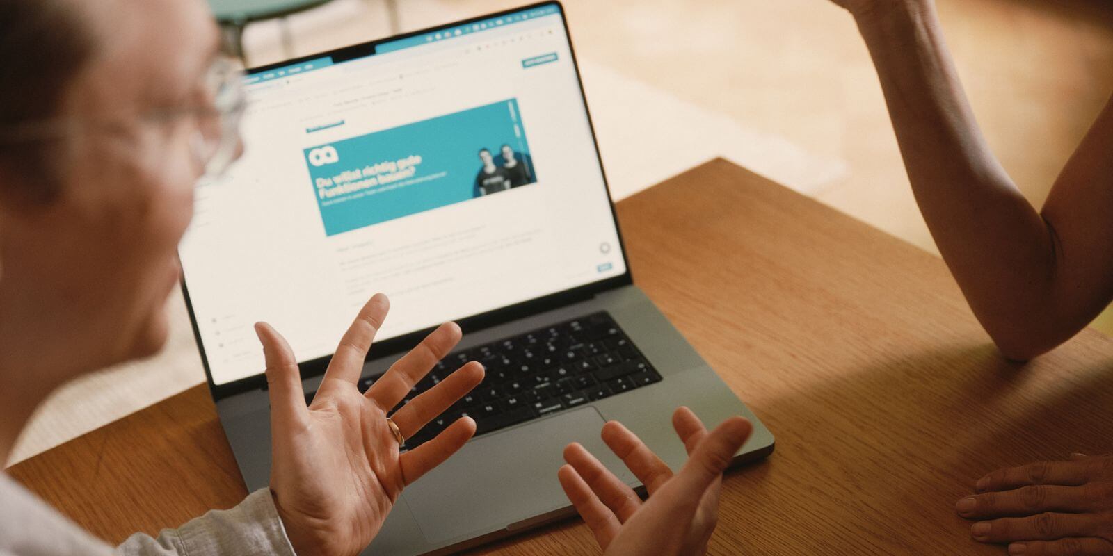 Mann zeigt auf Laptop und Software