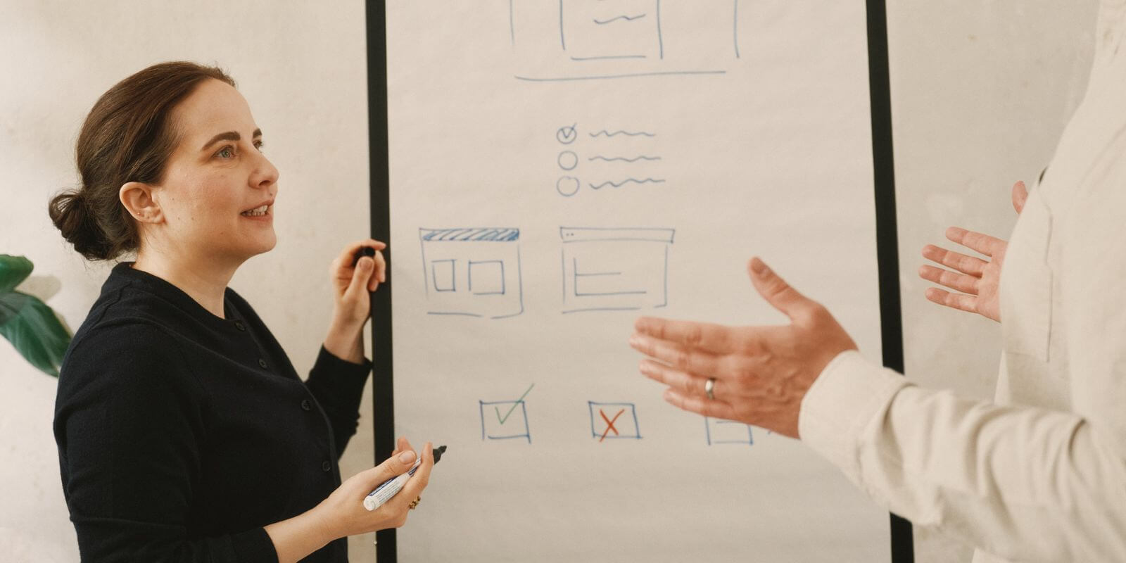 Frau steht vor Flipchart und erklärt