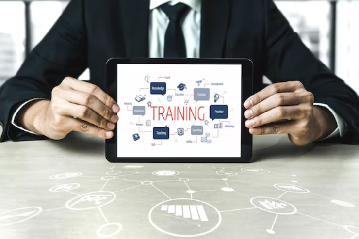 Business professional holding a digital tablet that displays the word training, representing Databuzz’s scalable online learning platform for UK education providers.