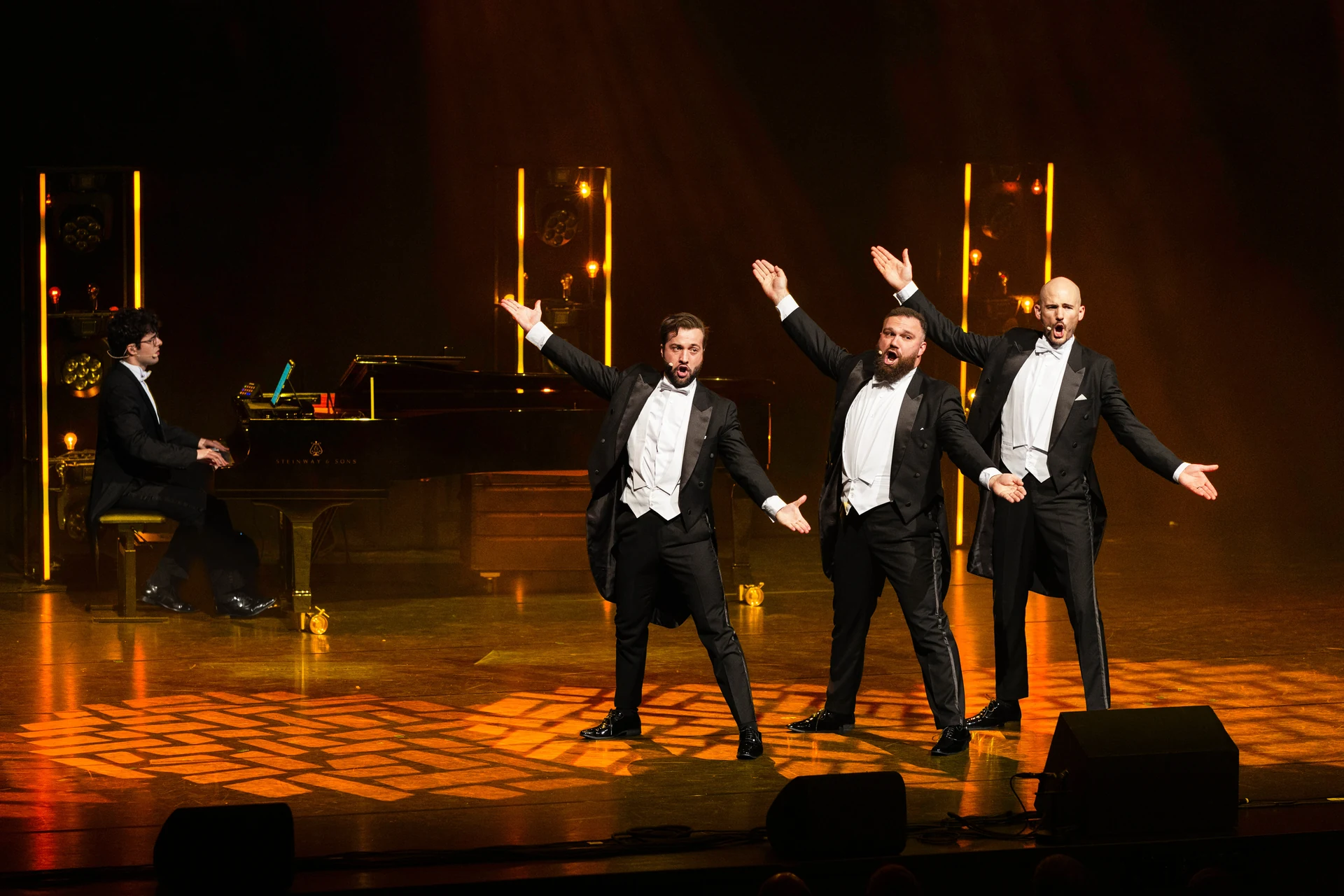 The Diamond Baritones zingen met hun pianist onder warme podiumverlichting.