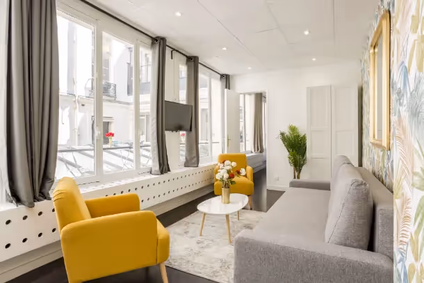 Le salon avec fauteuil jaune Cozy Apartment ND des Victoires