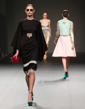 Des mannequins défilent sur un podium avec des vêtements de mode