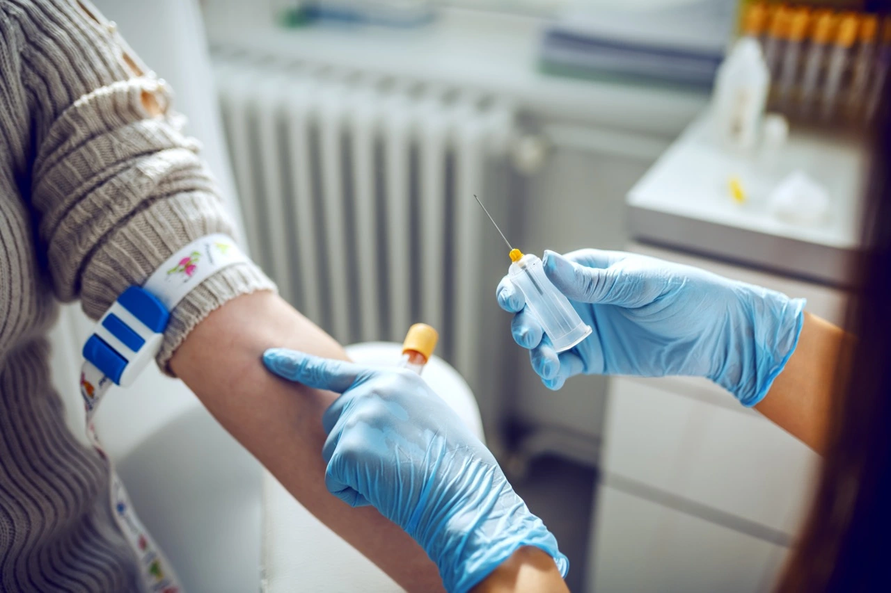 A pharmacist preparing to draw blood from a client.
