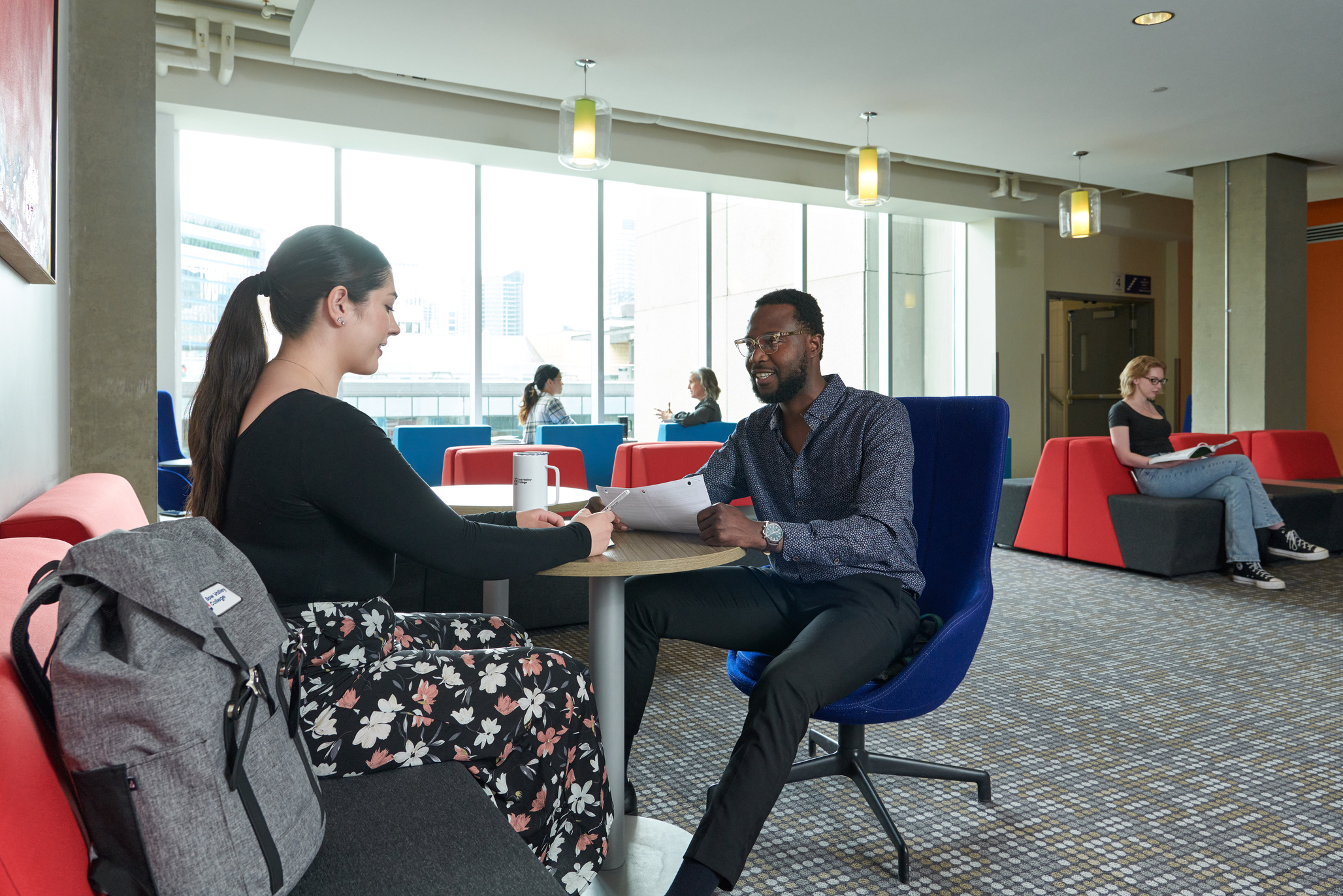 A couple of students studying together in a public study area at Bow Valley College North Campus.