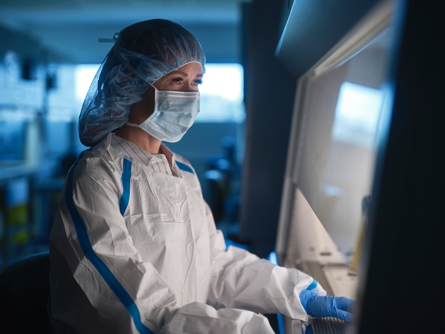 A student in protective scrubs working in one of health labs at Bow Valley College.