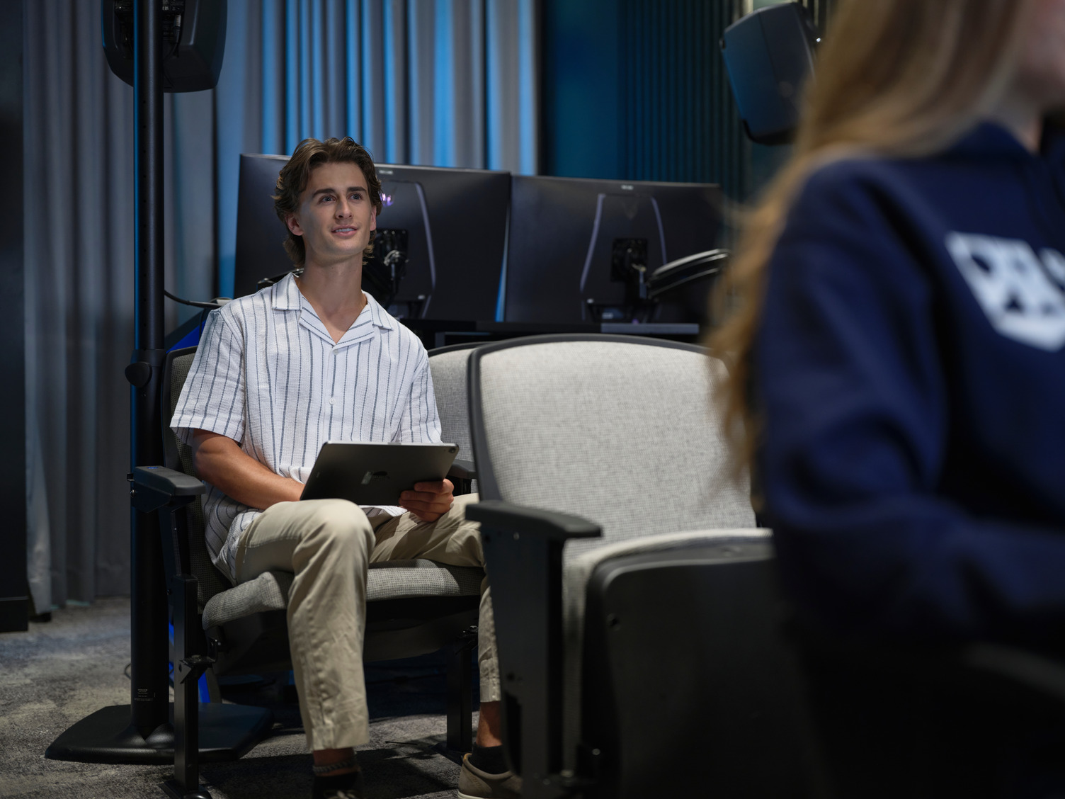 A student attending a classroom lecture in a theater hall.