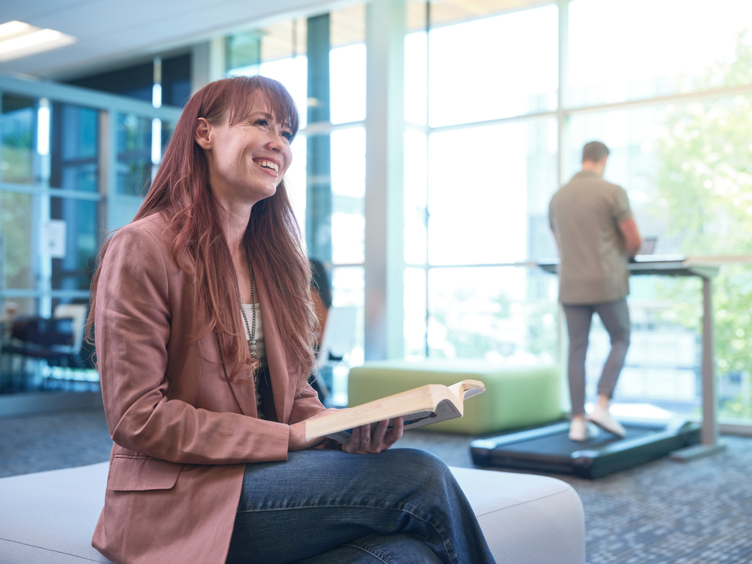 A female students reading a book in one of the lounge areas at Bow Valley College.