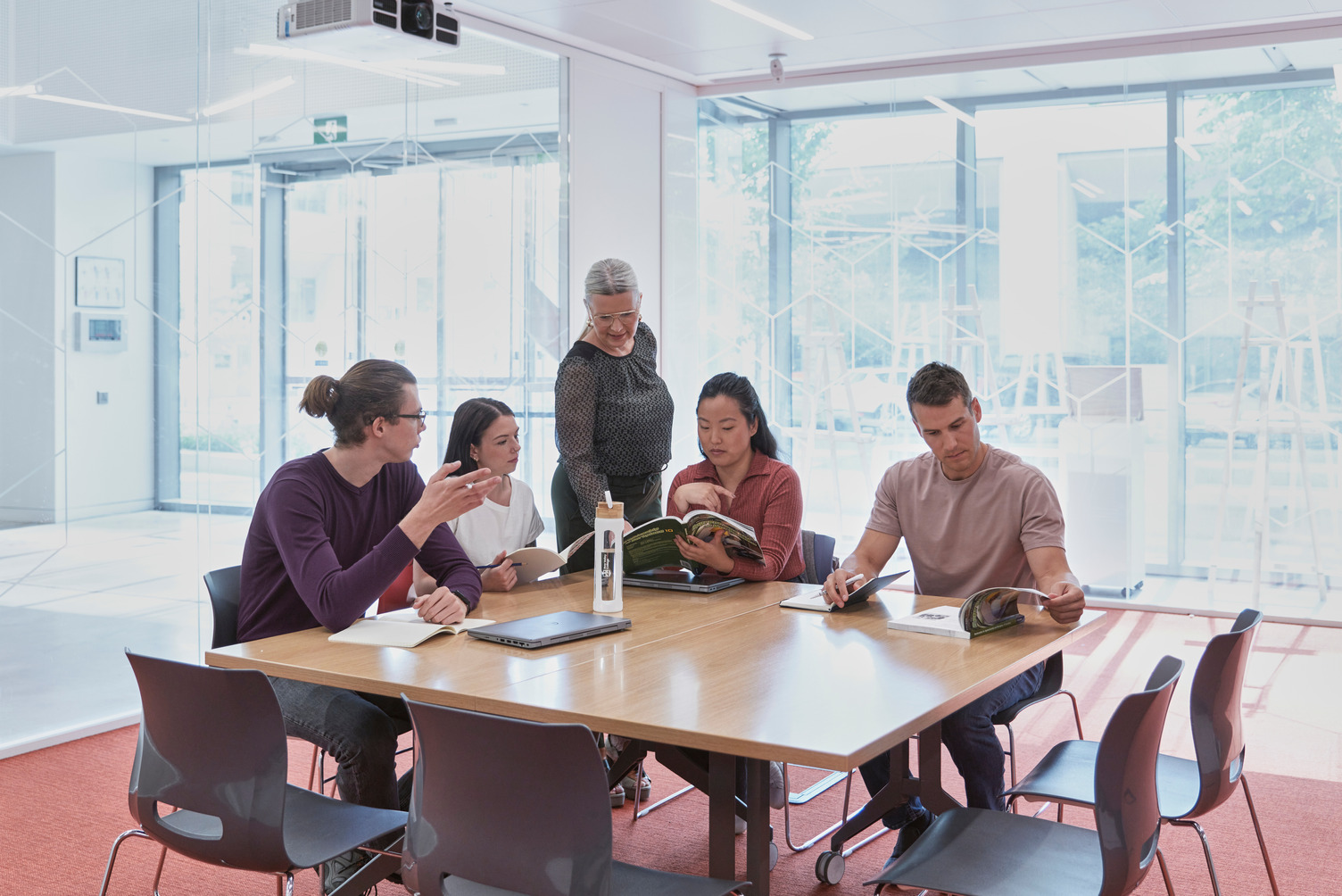 A group of students studying at a large table.